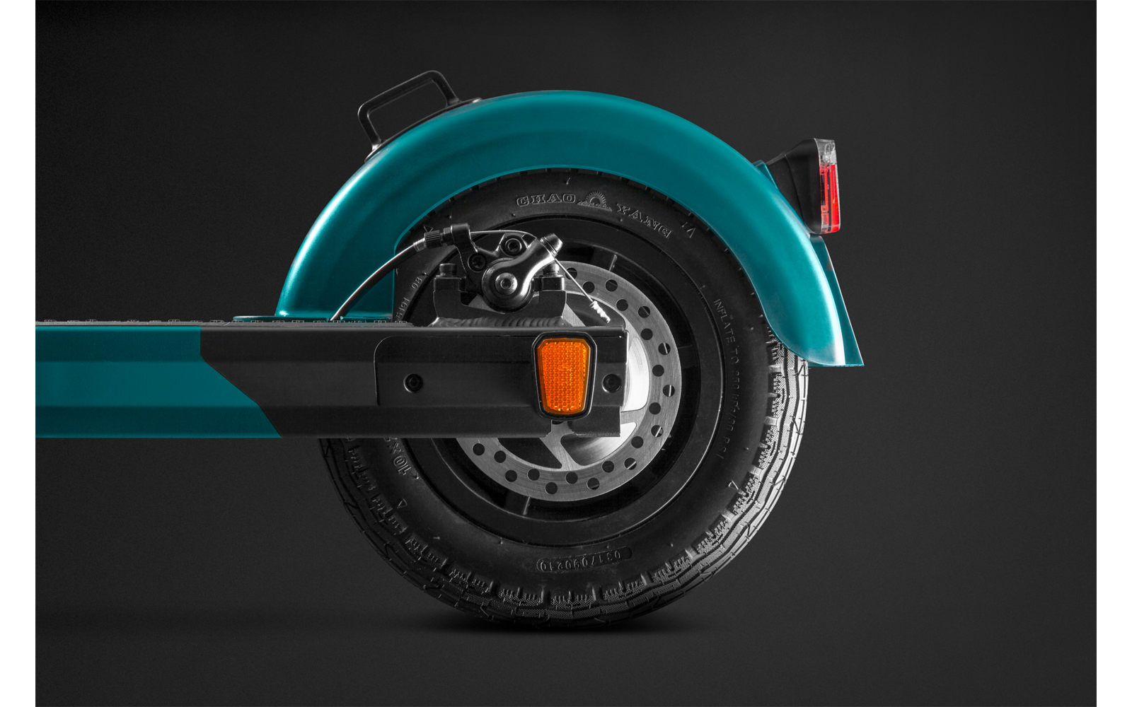 Primo piano di un monopattino elettrico blu con pneumatico nero e pinza del freno arancione