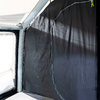 Window with semi-transparent black blackout film, view outside, dark wall and window frame inside the room