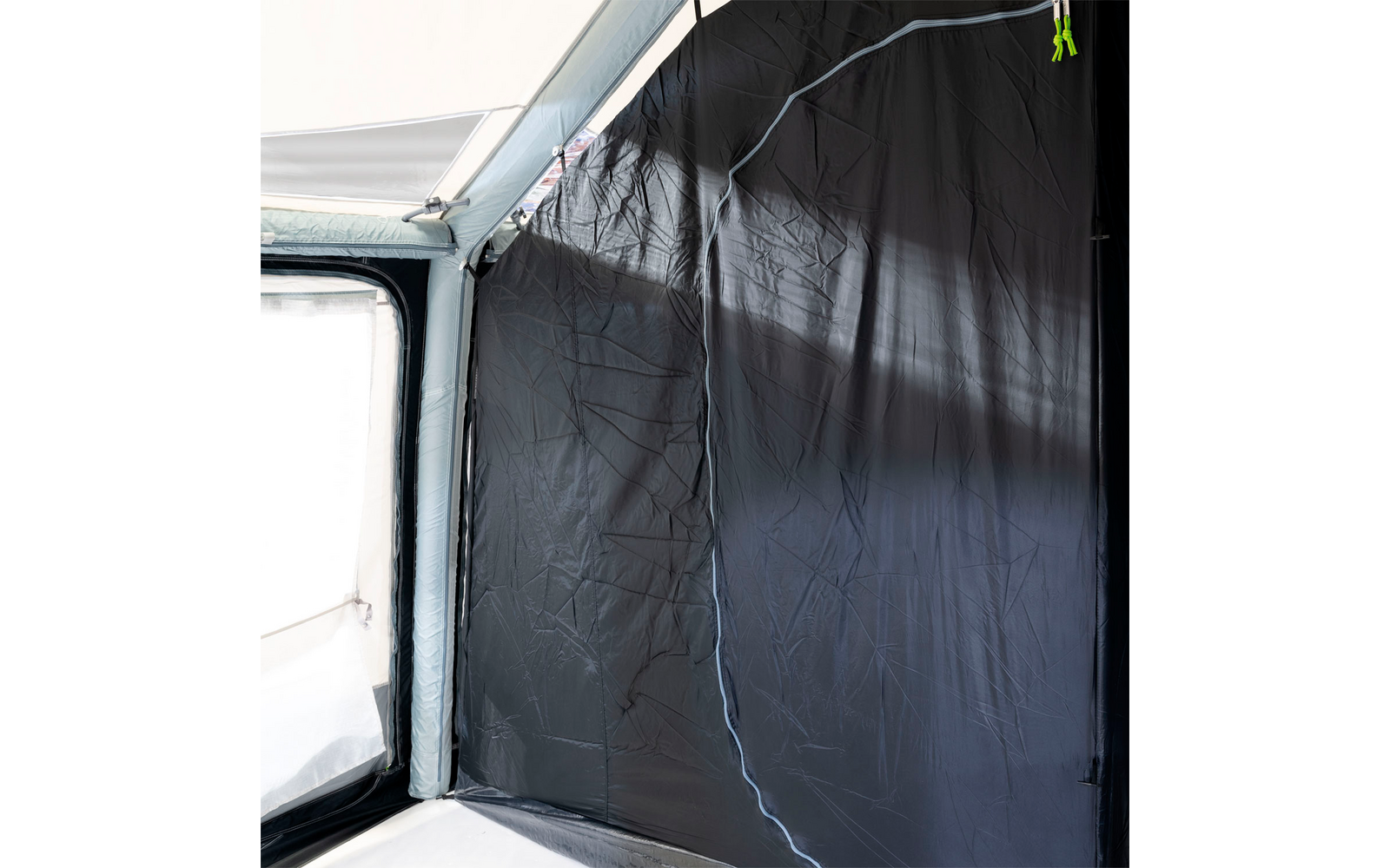Window with semi-transparent black blackout film, view outside, dark wall and window frame inside the room