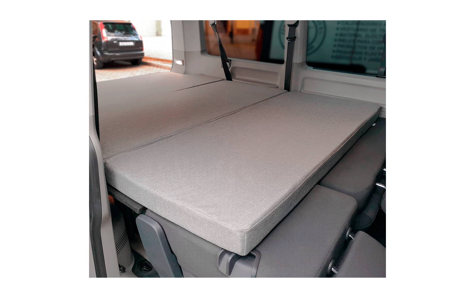 Innenraum eines Fahrzeugs mit umgeklappten, grauen Sitzpolstern