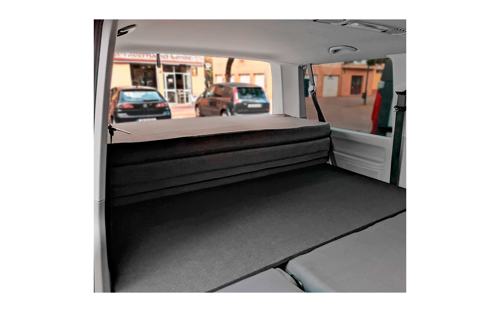 Innenansicht eines Fahrzeugs mit ausgeklapptem, flachem Sitz- oder Liegebereich