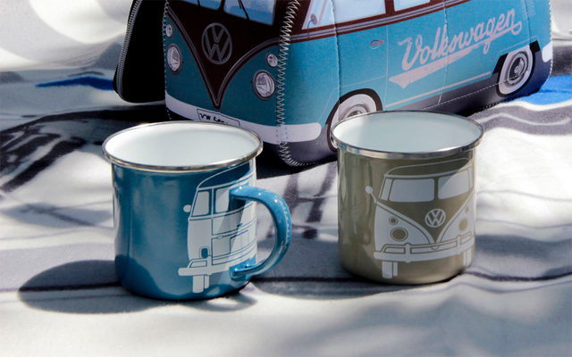 Two enamel mugs in blue and gray in front of a model Volkswagen bus