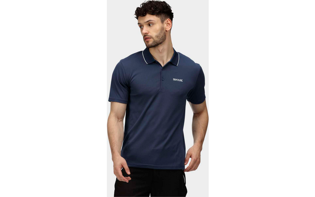 Mann mit kurzem dunklem Haar trägt ein dunkelblaues Poloshirt und schwarze Hosen, steht vor weißem Hintergrund