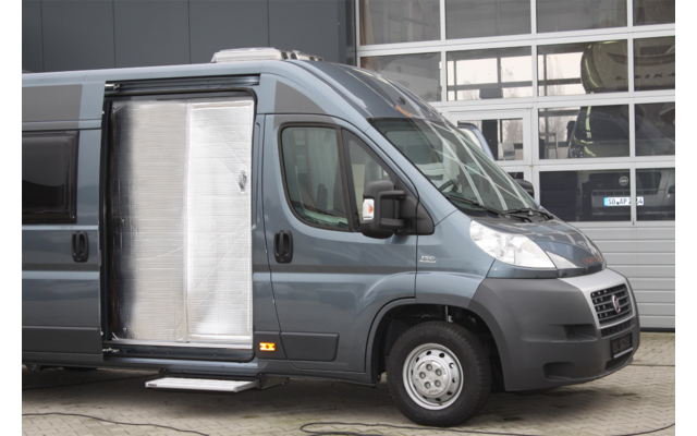 Gray van with open side door in front of a building