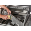 Hands cleaning a metal grill with a sponge