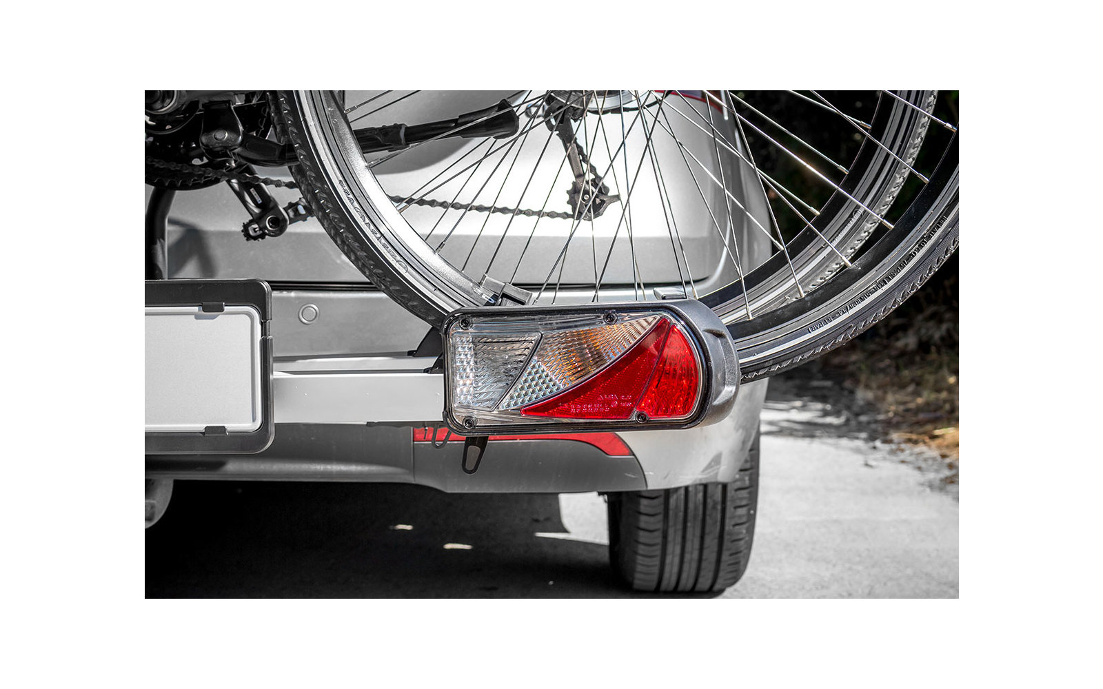 Rückleuchte eines Autos mit einem Fahrradträger und zwei Fahrrädern