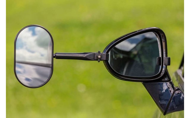 Ein Mann mit Bart und Brille hebt beide Hände mit nach oben gerichteten Handflächen neben dem Kopf