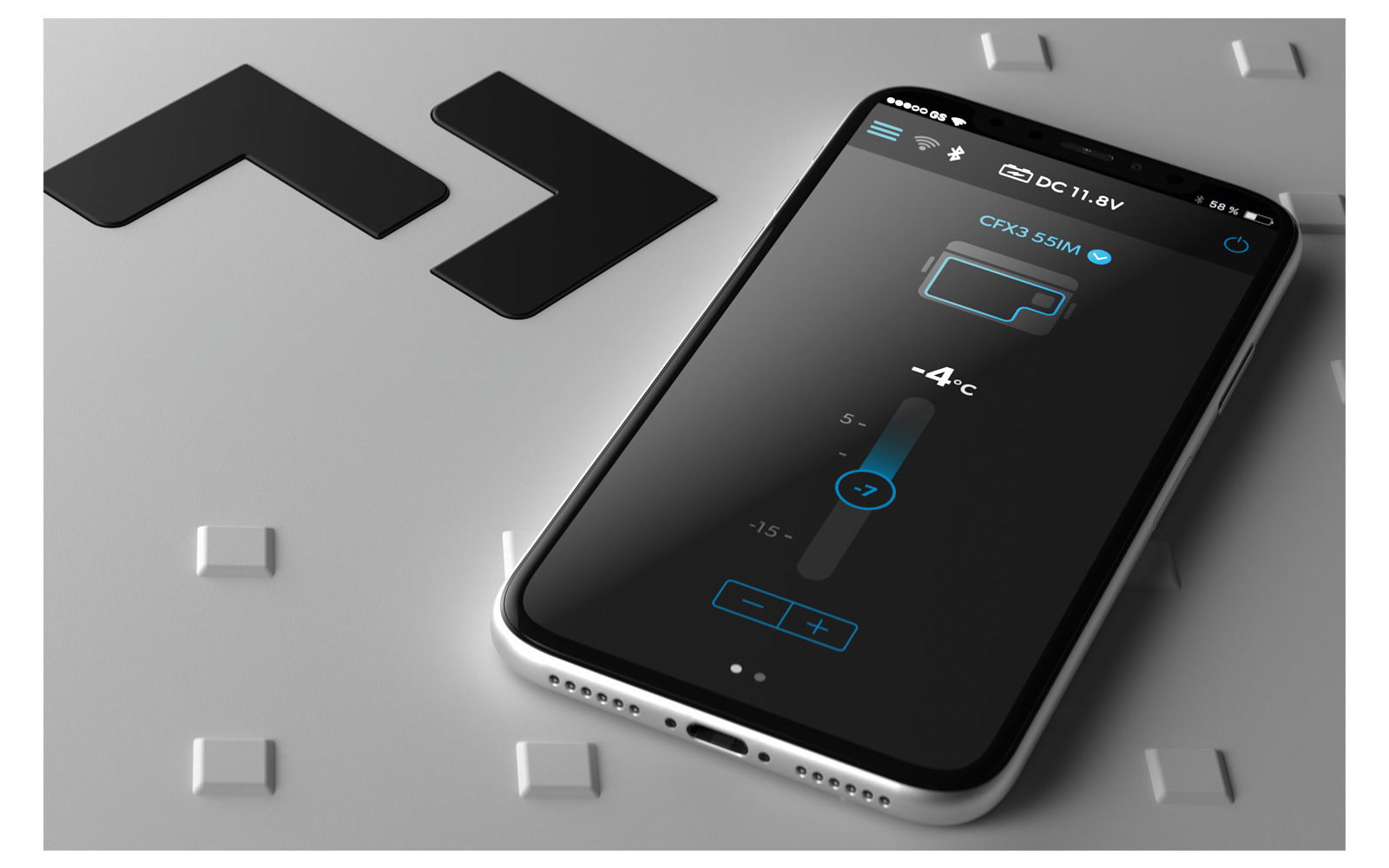 Mann sitzt auf Wiese, umgeben von Bäumen, mit Blick auf See und Berge bei Sonnenuntergang