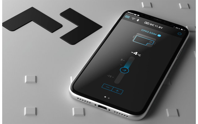 Mann sitzt auf Wiese, umgeben von Bäumen, mit Blick auf See und Berge bei Sonnenuntergang