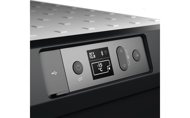 Ein roter Apfel auf einem Holztisch neben einer halben Zitrone und grünem Blatt