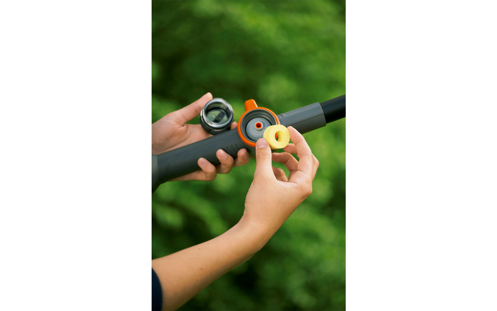 Hands opening a black and orange device cover in front of a green background