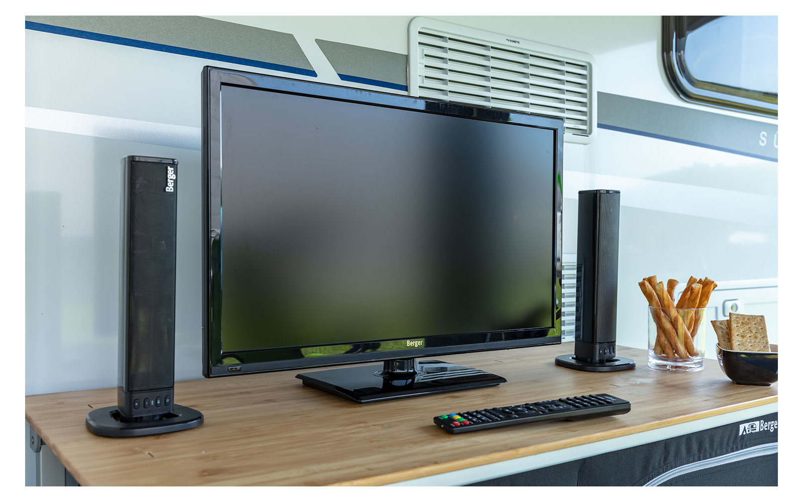 Fernseher auf einem Tisch mit Lautsprecher und Dekoration im Hintergrund