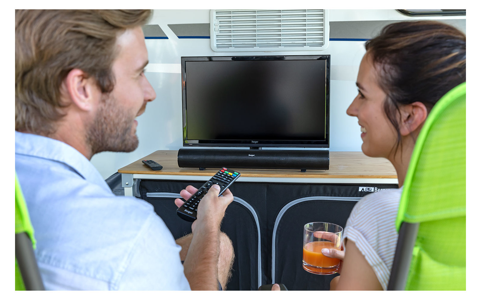 Ein Mann und eine Frau sitzen an einem Tisch und schauen sich einen Laptop an