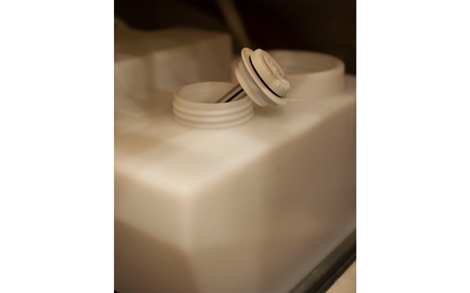 Weiße runde Tabletten auf einem weißen Behälter