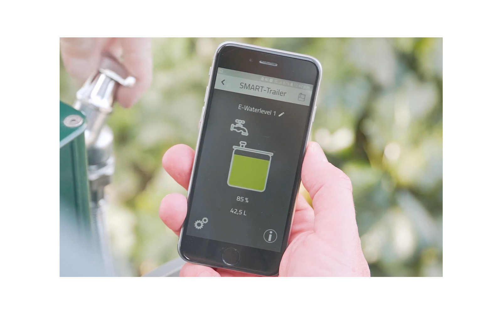 Hand hält Smartphone mit Anzeige einer Batterie-App