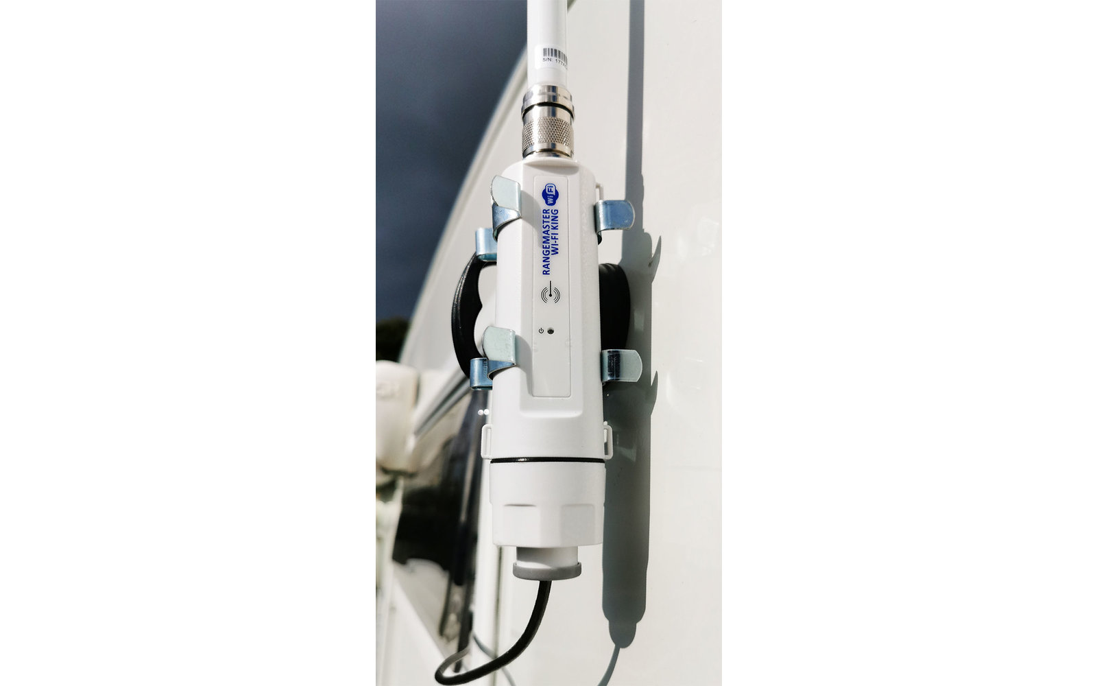 Weißes elektronisches Gerät mit Anschlusskabel an einer Wand befestigt