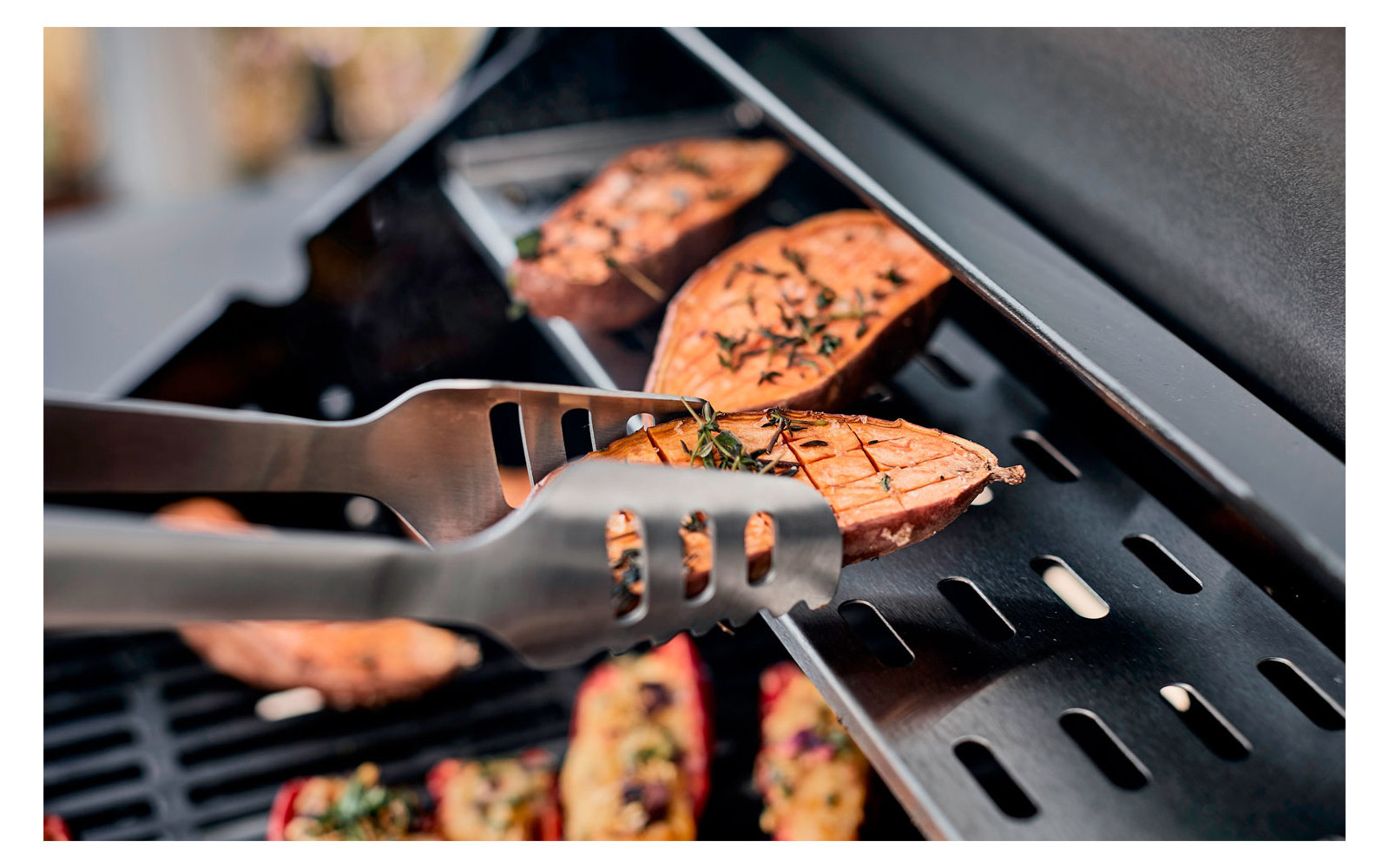 Gegrillte Lachsfilets auf einem Grillrost mit Grillzange