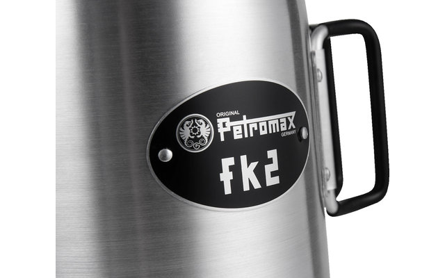 Nahaufnahme eines silbernen Metallbehälters mit schwarzem Griff und rundem, schwarzem Aufkleber mit weißem Text