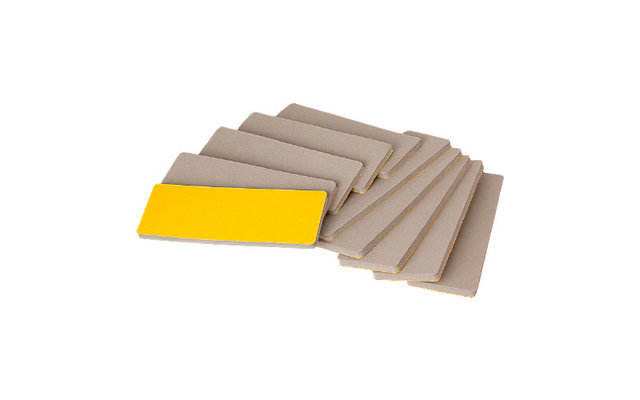 Mehrere graue Schleifblätter, eines davon mit gelber Fläche