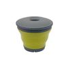 Vaso plegable verde con tapa gris sobre fondo blanco