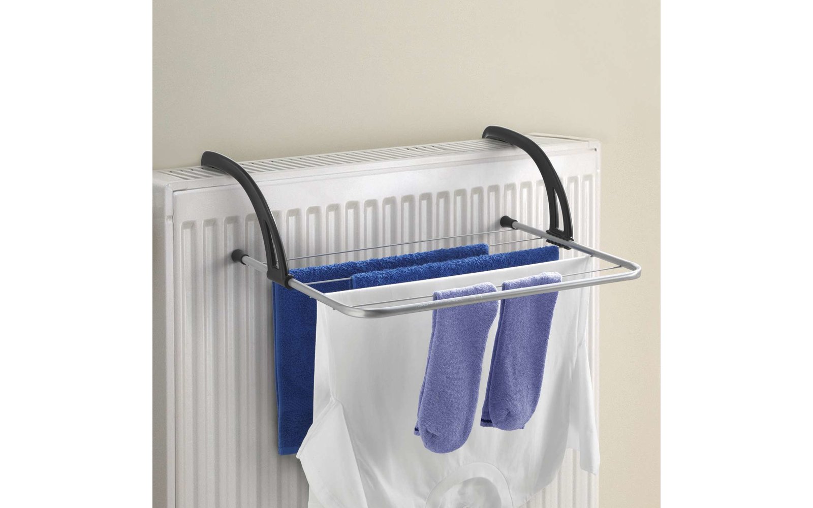 Ein Wäscheständer mit Socken und einem blauen Handtuch vor einem Heizkörper