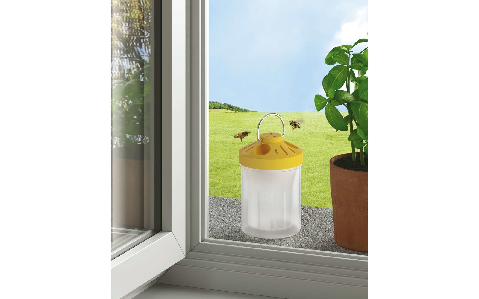 Offenes Fenster mit Blick auf eine grüne Wiese, auf der Fensterbank eine gelbe Hummel-Falle und ein Blumentopf mit einer Pflanze