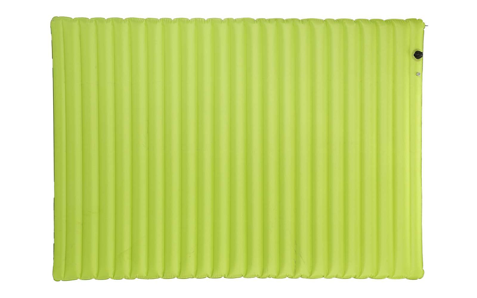 Ein schwarzer Hund sitzt auf einer roten Decke mit weißen Punkten