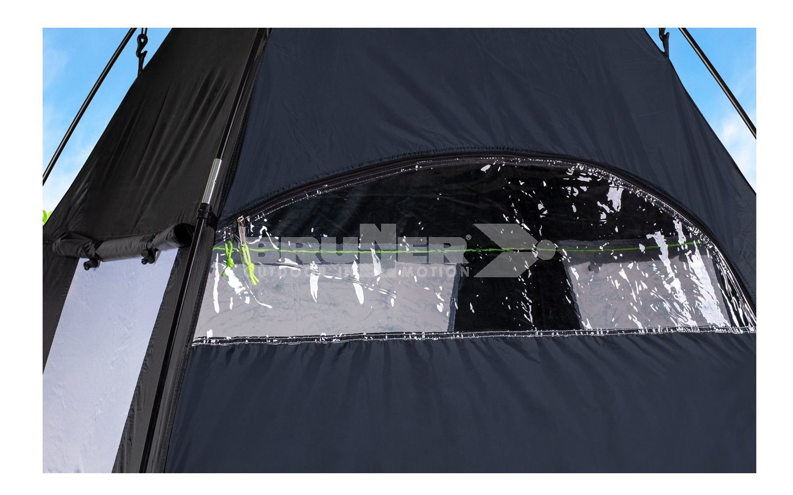 Vista attraverso una finestra rettangolare in una tenda nera, cielo azzurro sullo sfondo