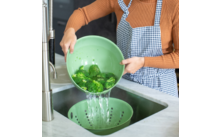 Person wäscht grüne Paprika in einer Spüle