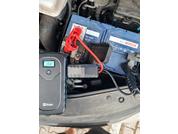 Auto-Batterie mit angeschlossenen Kabeln und einem digitalen Messgerät