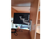 Brazo de monitor con pantalla fijada a un escritorio