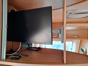 Televisor de pantalla plana sobre una mesa de madera frente a una ventana con cortinas