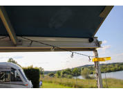 Open tailgate of a vehicle with view of a country road and fields in the background