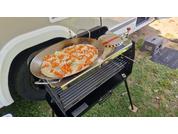Pizza sur un gril devant un camping-car