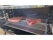 Deux morceaux de viande crus sont placés sur une grille dans un grill