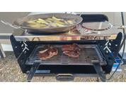 Grill avec de la viande et une poêle avec des frites sur une grille