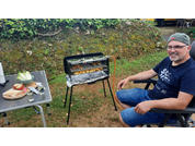 Homme assis sur une chaise en plein air jouant de la guitare