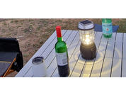 Wine bottle, glass, and lantern on a garden table