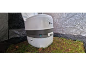 Toilette de camping blanche portable à l'intérieur d'une tente sur l'herbe
