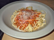 Teller mit Spaghetti, Tomatensauce und geriebenem Käse