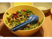 Schüssel mit gemischtem Salat und blauem Besteck