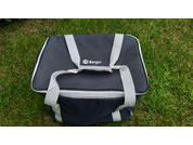 Schwarze rechteckige Softtasche mit hellgrauen Tragegriffen und Reißverschluss, weißes Berger-Logo oben, liegend auf Gras