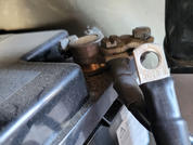 Nahaufnahme eines Autobatterie-Anschlusses mit Metallklemme und schwarzem Kabel an der Batterie