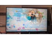 Écran de télévision avec à gauche une liste de langues (ENGLISH, DEUTSCH, DANSK, SUOMI, NORSK, SVENSKA) et à droite une photo de quatre personnes sur un fond clair
