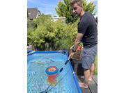 Homme debout à côté d'un étang tenant une épuisette avec des poissons à l'intérieur