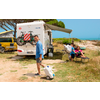 Woman with dog in front of a camper van on a sunny day