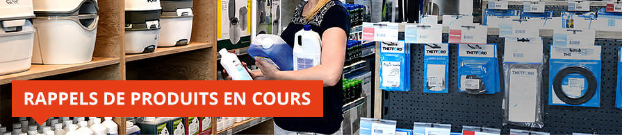 Rayons de magasin avec articles &eacute;lectroniques emball&eacute;s, produits suspendus, une personne et une banni&egrave;re rouge portant le texte &laquo;RAPPELS DE PRODUITS EN COURS&raquo;