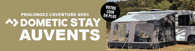 Caravane avec auvent fix&eacute; sur de l'herbe, deux personnes assises &agrave; une table sous l'auvent, texte visible : EINFACH L&Auml;NGER UNTERWEGS >> DOMETIC STAY VORZELTE et pastille ronde DEIN EXTRA RAUM