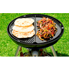 Grill mit Fleisch und Fladenbrot auf Rasen