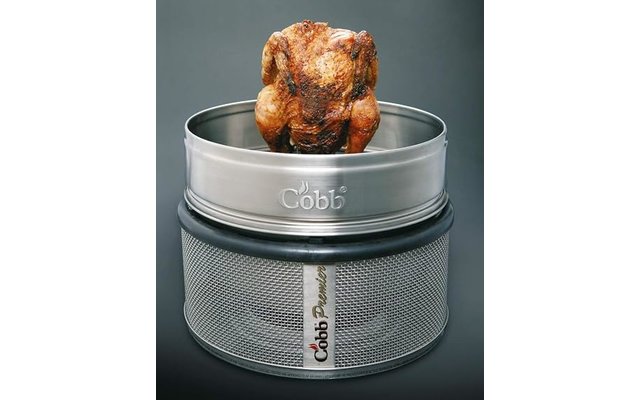 Braun gebräuntes ganzes Hähnchen auf rundem Metallgrill mit Aufschrift Cobb, grauer Hintergrund